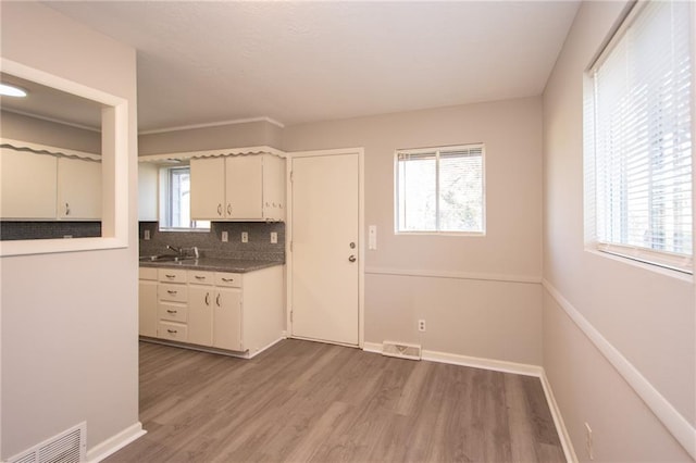 kitchen featuring sink, light wood-type flooring, and decorative backsplash