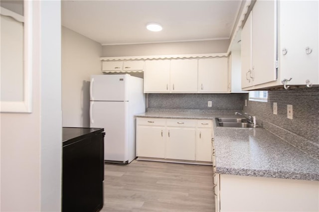 kitchen featuring light hardwood / wood-style floors, white cabinetry, sink, tasteful backsplash, and white fridge