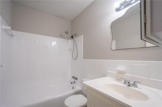 full bathroom with  shower combination, vanity, toilet, and tile walls