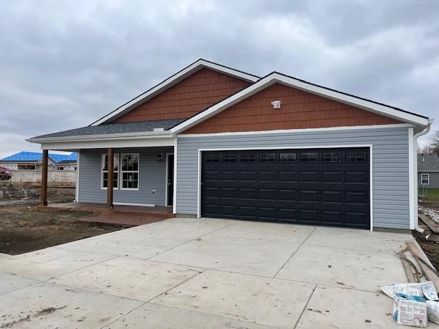 view of front of property featuring covered porch and a garage