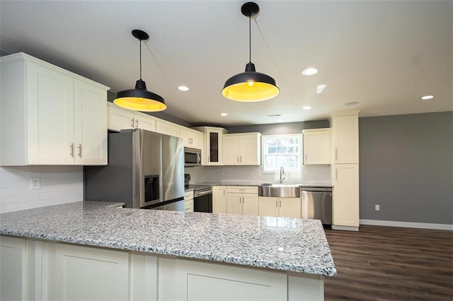 kitchen with sink, kitchen peninsula, dark hardwood / wood-style flooring, white cabinetry, and stainless steel appliances