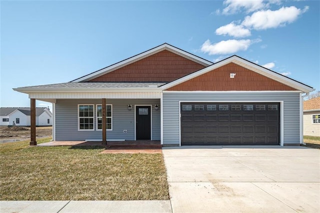 view of front facade featuring a porch, an attached garage, driveway, and a front yard