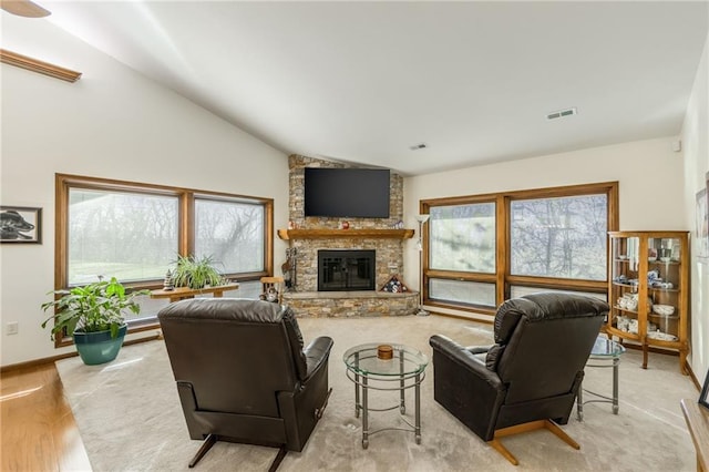 living room with a fireplace, light hardwood / wood-style flooring, and vaulted ceiling