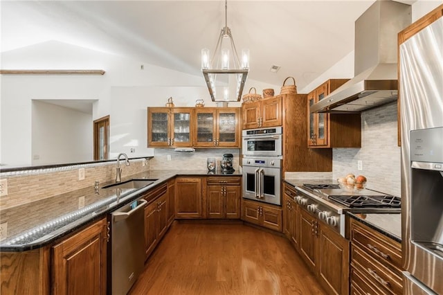 kitchen with appliances with stainless steel finishes, backsplash, dark hardwood / wood-style flooring, wall chimney exhaust hood, and vaulted ceiling