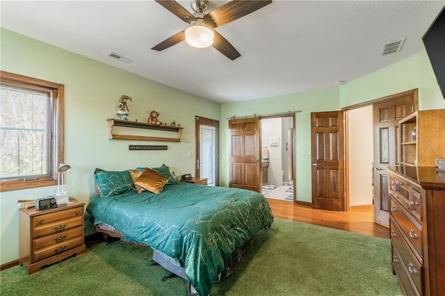 bedroom featuring ceiling fan, hardwood / wood-style floors, and ensuite bathroom