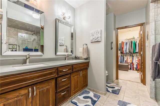 bathroom with a shower with door, vanity, and tile patterned flooring