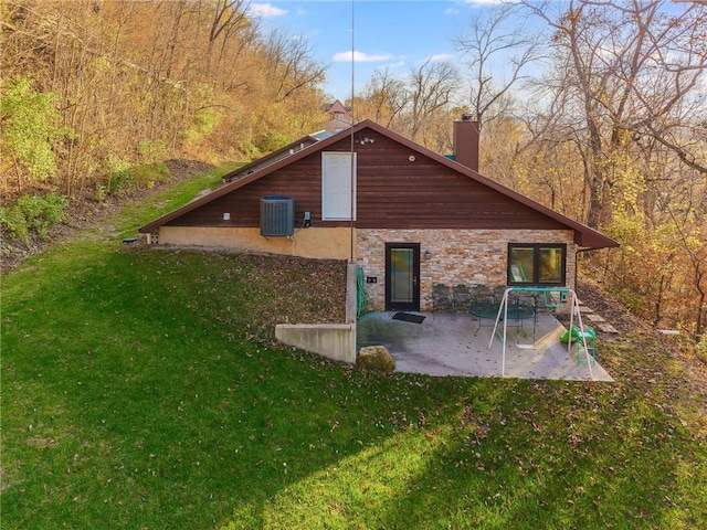 rear view of house featuring central air condition unit, a yard, and a patio