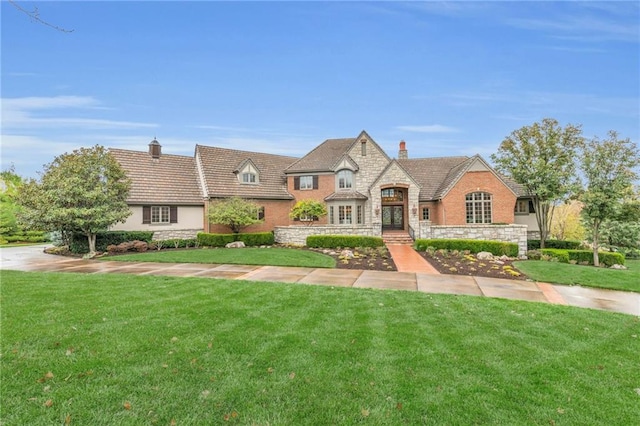 tudor home featuring a front lawn