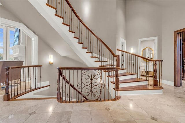 stairway featuring tile patterned floors and a towering ceiling