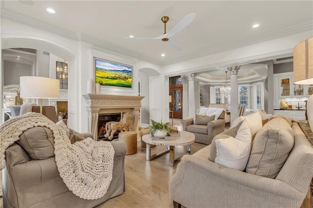 living room with ornamental molding, decorative columns, and light hardwood / wood-style floors