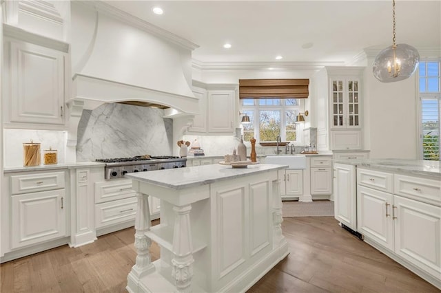 kitchen with white cabinetry, light wood-type flooring, a healthy amount of sunlight, and sink