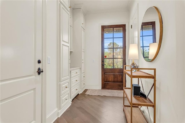 doorway with ornamental molding and hardwood / wood-style floors