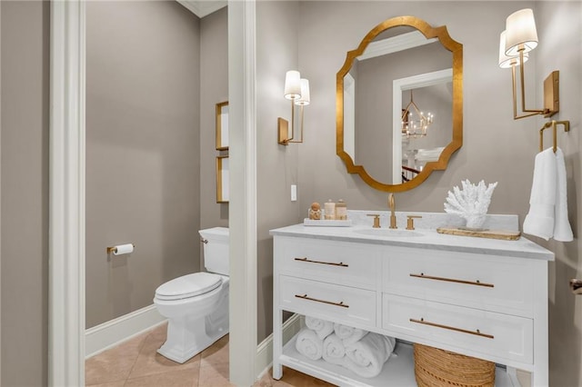 bathroom featuring toilet, vanity, an inviting chandelier, and tile patterned flooring