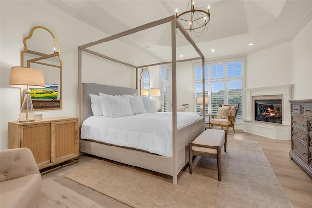 bedroom featuring ornamental molding, light hardwood / wood-style flooring, and a notable chandelier