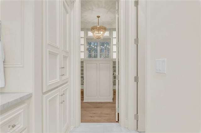 hallway with a notable chandelier and light hardwood / wood-style flooring