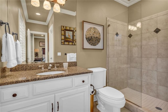 bathroom featuring vanity, toilet, a tile shower, and crown molding