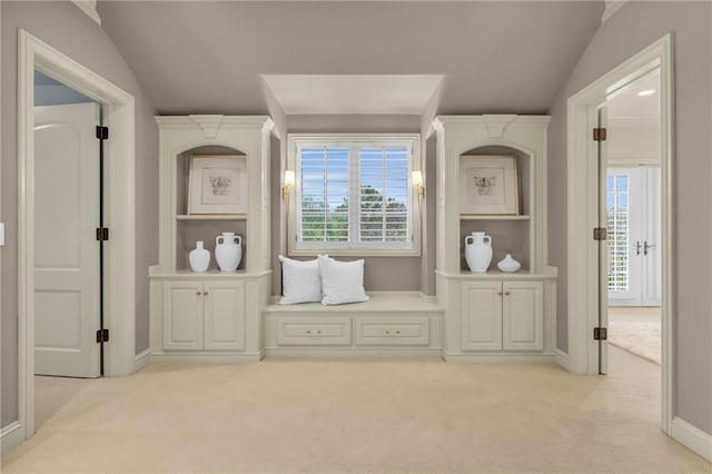 interior space with vaulted ceiling and light colored carpet