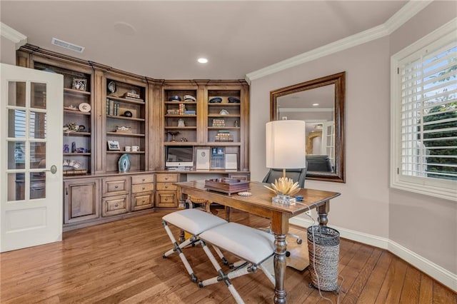 office space with light wood-type flooring and ornamental molding