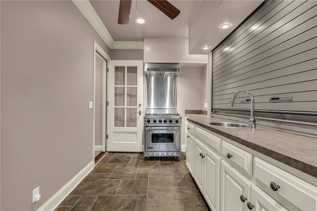 kitchen featuring white cabinets, sink, oven, ceiling fan, and crown molding