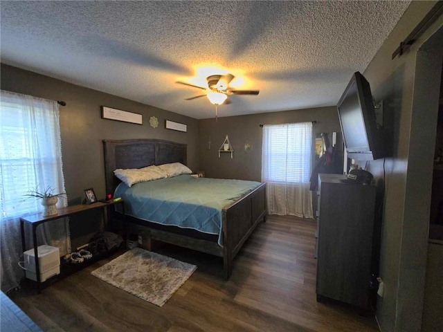 bedroom with ceiling fan, dark hardwood / wood-style floors, and a textured ceiling