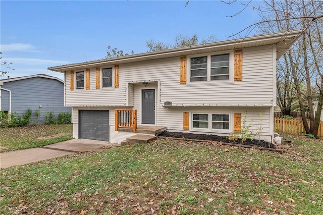 split foyer home featuring a garage and a front yard