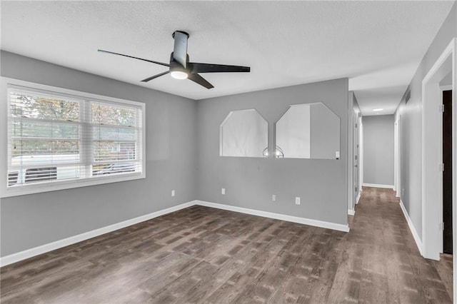 empty room featuring a textured ceiling, dark hardwood / wood-style floors, and ceiling fan