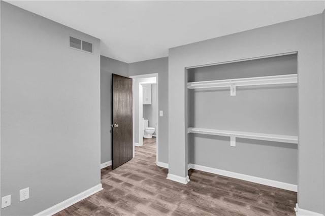 unfurnished bedroom with a closet and hardwood / wood-style floors