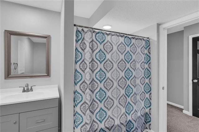 bathroom with vanity, a textured ceiling, and curtained shower