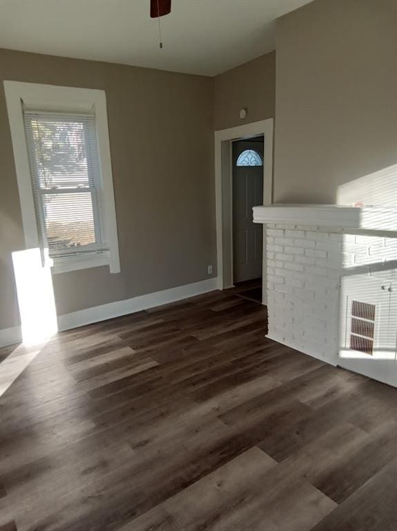 unfurnished living room with ceiling fan and dark hardwood / wood-style flooring