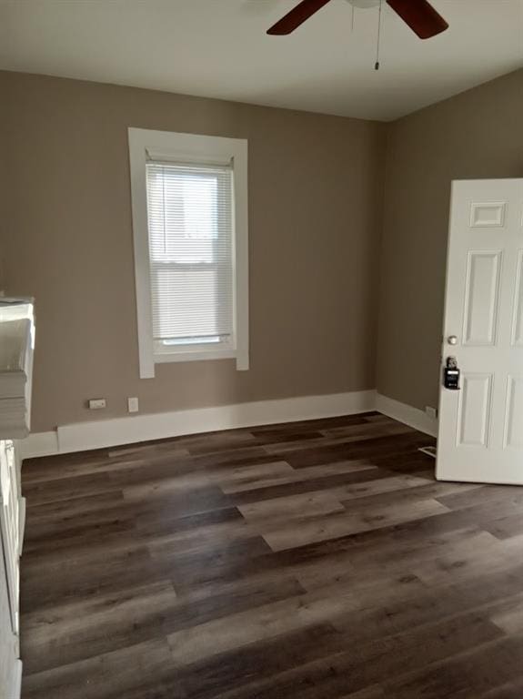 empty room featuring dark wood-type flooring and ceiling fan