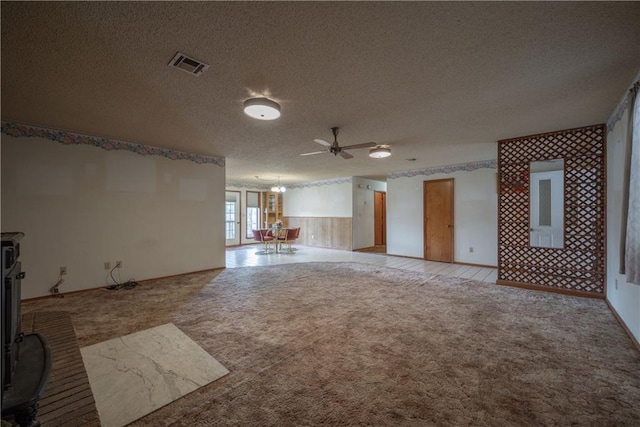 unfurnished living room with ceiling fan, light colored carpet, and a textured ceiling