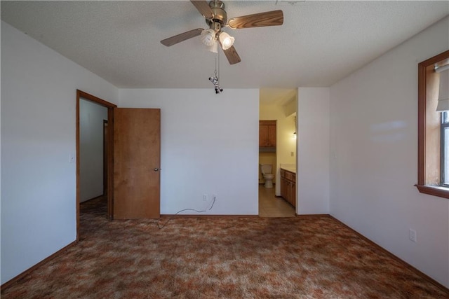 carpeted spare room with a textured ceiling and ceiling fan