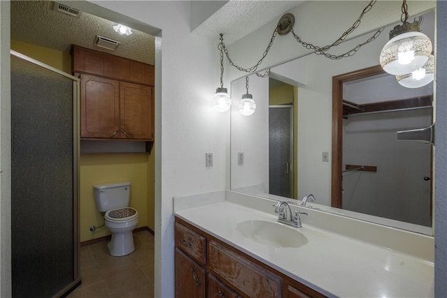 bathroom featuring walk in shower, tile patterned floors, a textured ceiling, toilet, and vanity