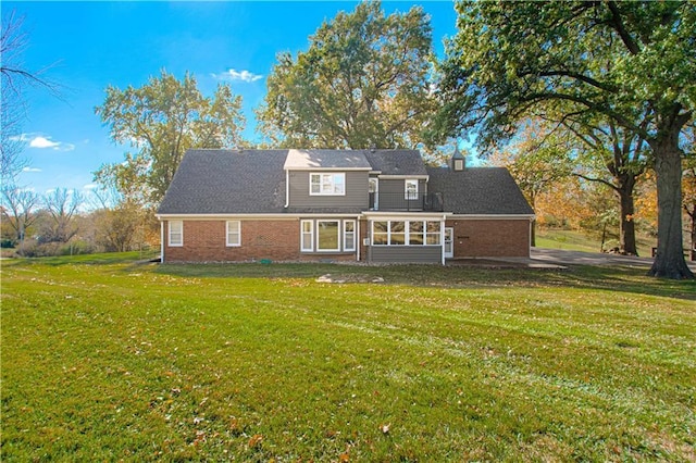 back of house featuring a sunroom and a lawn