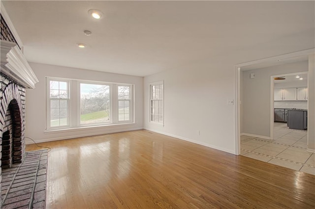 unfurnished living room featuring a fireplace and light hardwood / wood-style flooring