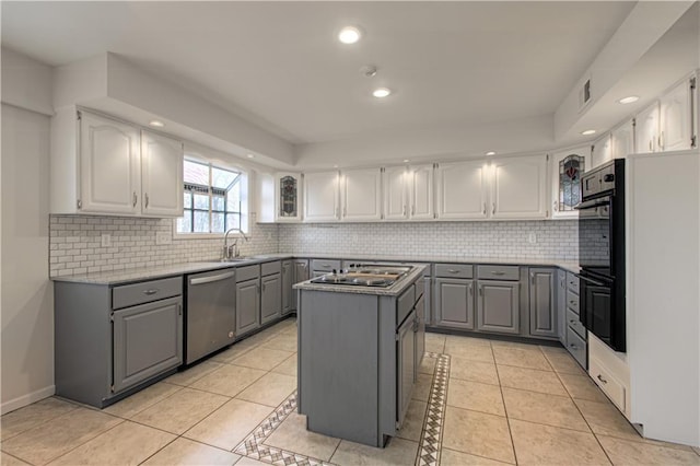 kitchen with light tile patterned flooring, stainless steel appliances, gray cabinetry, and a kitchen island