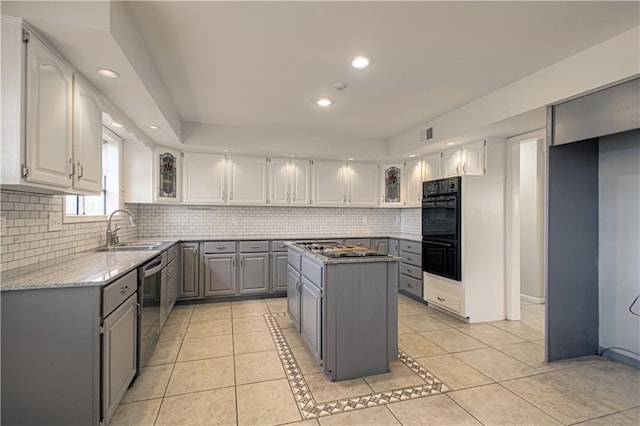 kitchen featuring sink, light tile patterned floors, gray cabinets, and a kitchen island