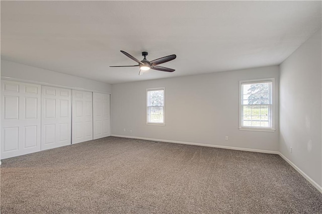 unfurnished bedroom with ceiling fan, a closet, and carpet