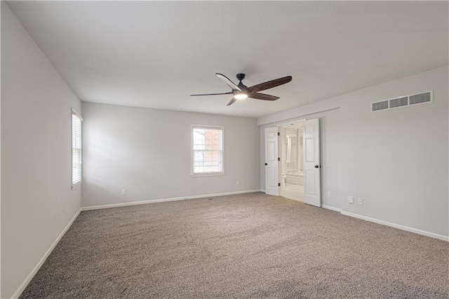 carpeted spare room with ceiling fan