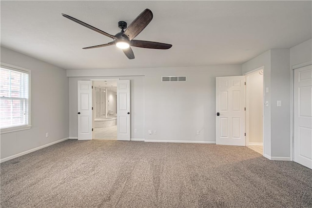 unfurnished bedroom featuring ceiling fan, carpet flooring, and ensuite bath