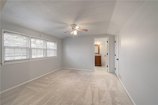 carpeted empty room featuring ceiling fan and lofted ceiling