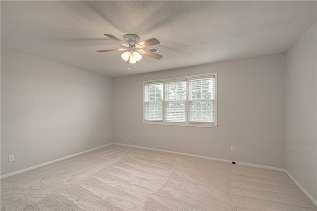 spare room featuring light carpet and ceiling fan