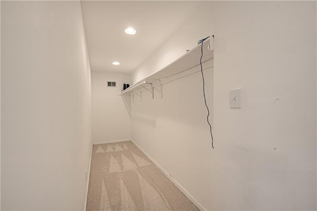 spacious closet with light colored carpet