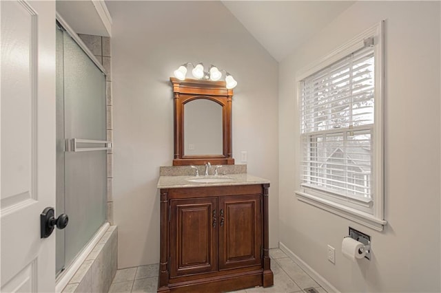 bathroom with vaulted ceiling, tile patterned floors, walk in shower, and vanity