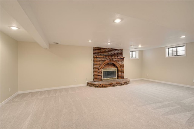 unfurnished living room with light colored carpet, beamed ceiling, and a fireplace