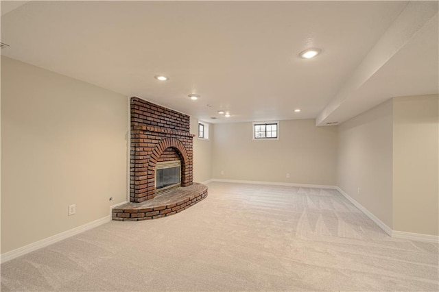 unfurnished living room with a brick fireplace and light colored carpet