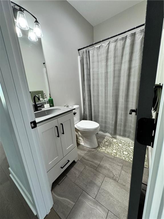 bathroom featuring a shower with shower curtain, vanity, and toilet