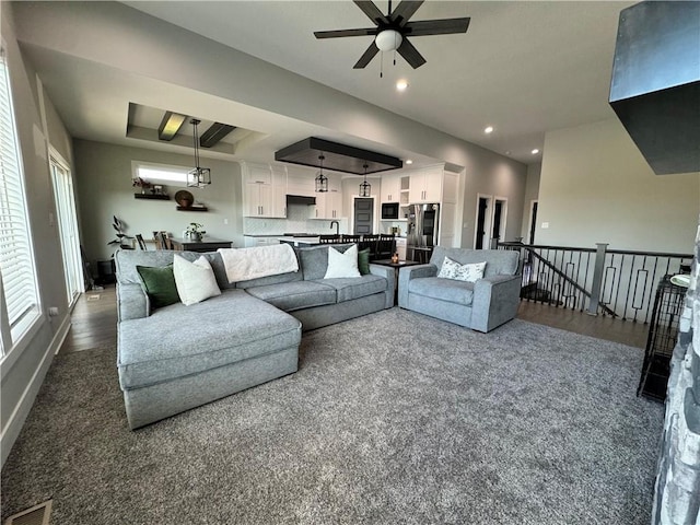 living room with ceiling fan and dark colored carpet