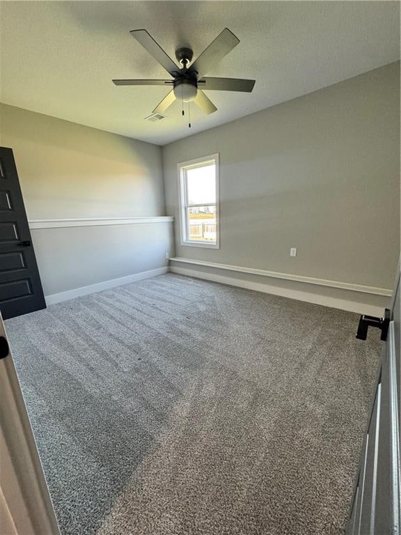 carpeted spare room with ceiling fan