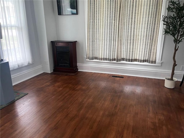 unfurnished living room with dark hardwood / wood-style floors